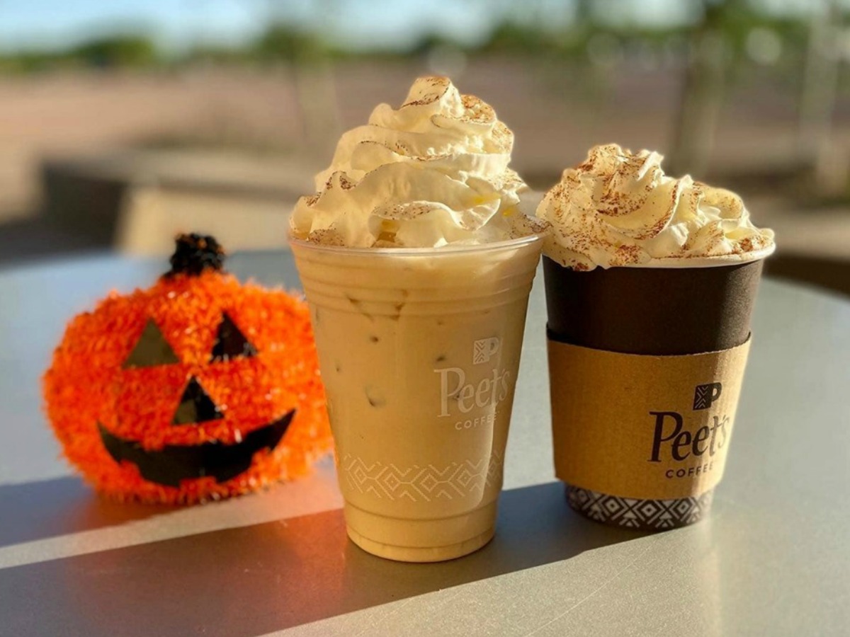 two cups of coffee next to ornamental pumpkin