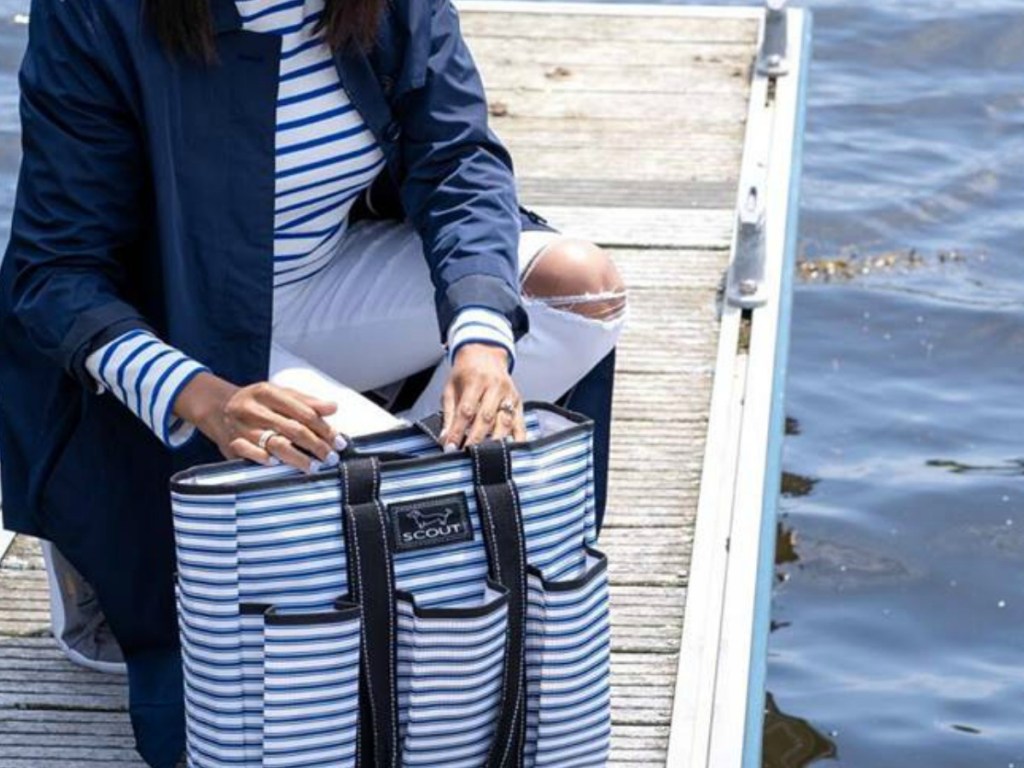 woman by lake looking in bag