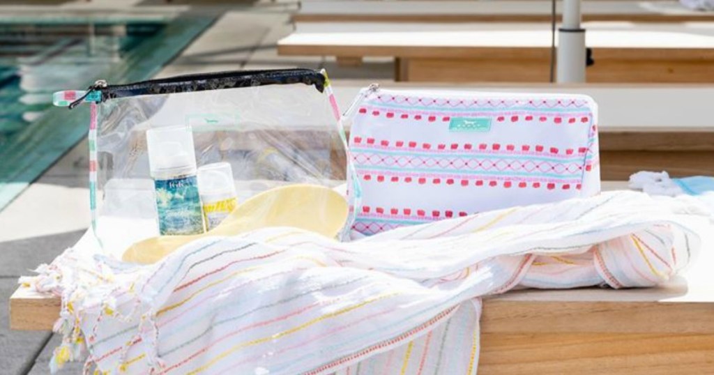 bags on table with fringed towel