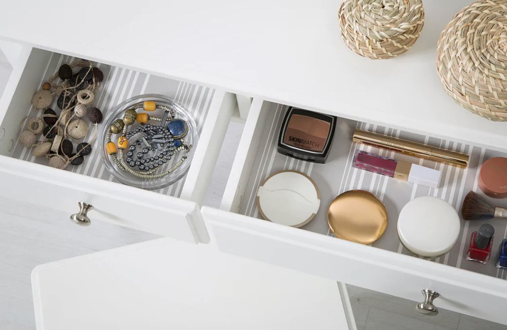 white vanity drawers open with baskets and makeup inside