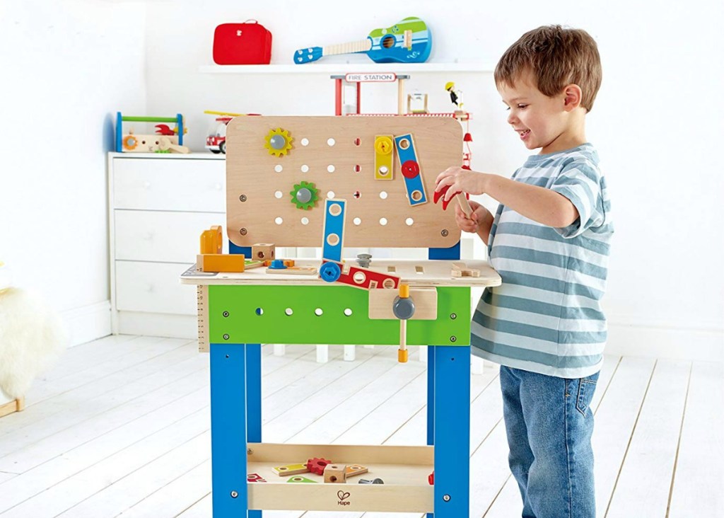 Boy playing with a Hape Master Workbench