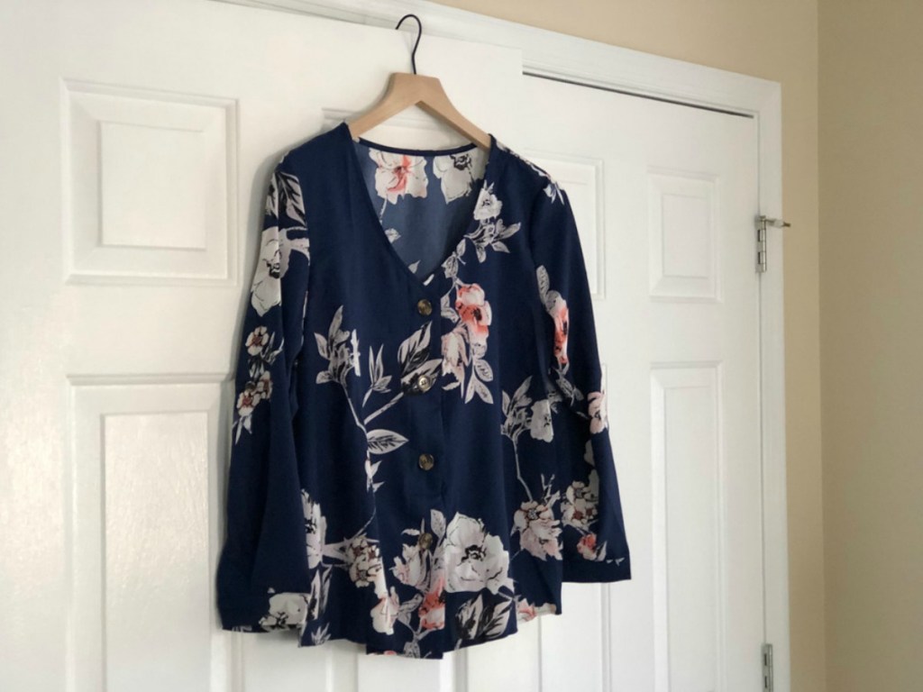 navy blue and floral shirt hanging on a door