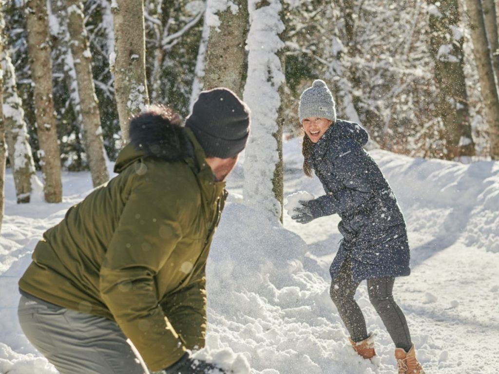 man and women having a snow fight wearing Columbia jackets