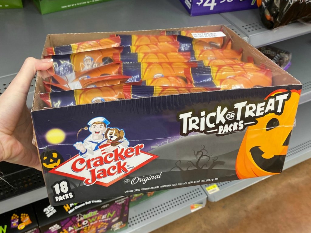 Hand holding Cracker Jack Trick or Treat Packs in store near Walmart shelf