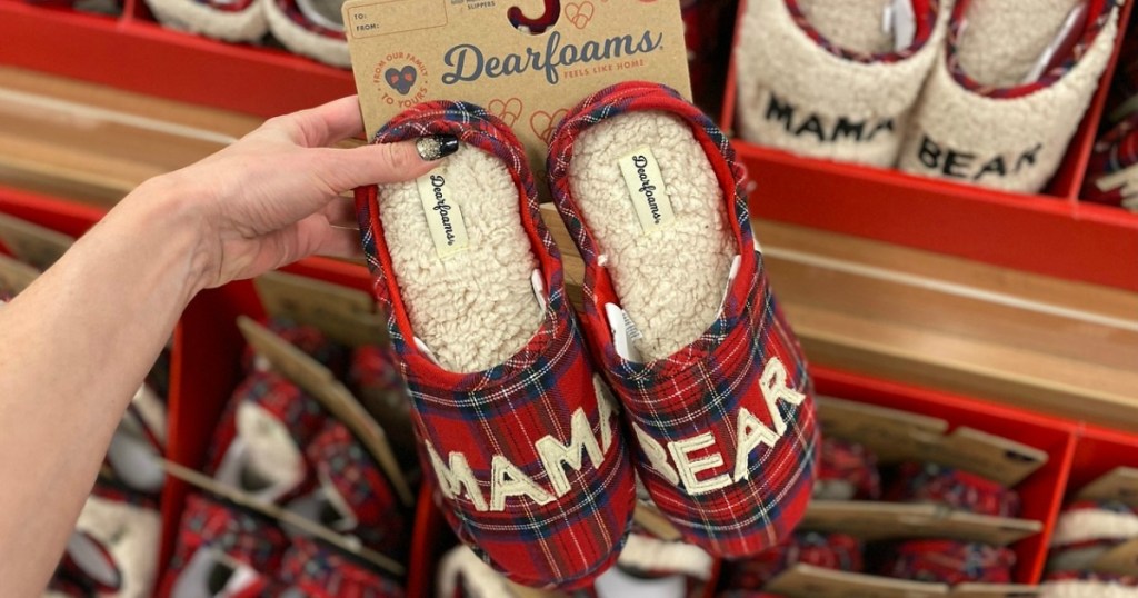 Woman holding a pair of red plaid Dearfoams Matching Slippers