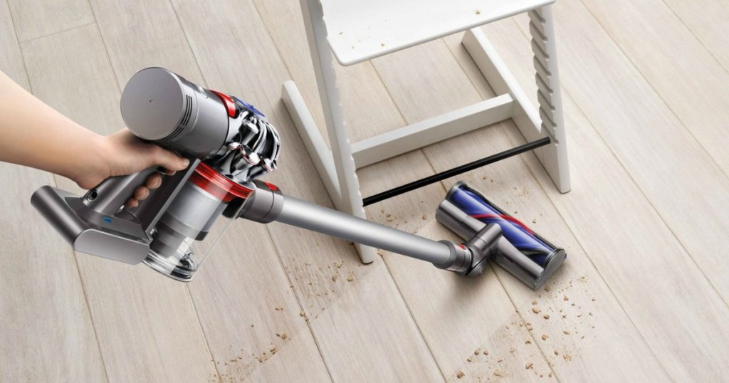 hand using Dyson V7 Motorhead Origin vacuuming up hardwood floor