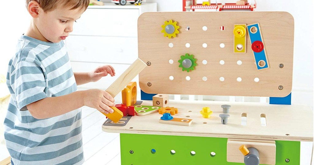 Young boy playing with a kids workbench