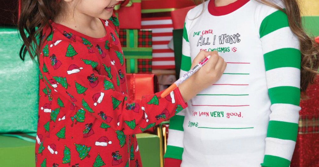 Two kids wearing Chasing Fireflies holiday pajamas