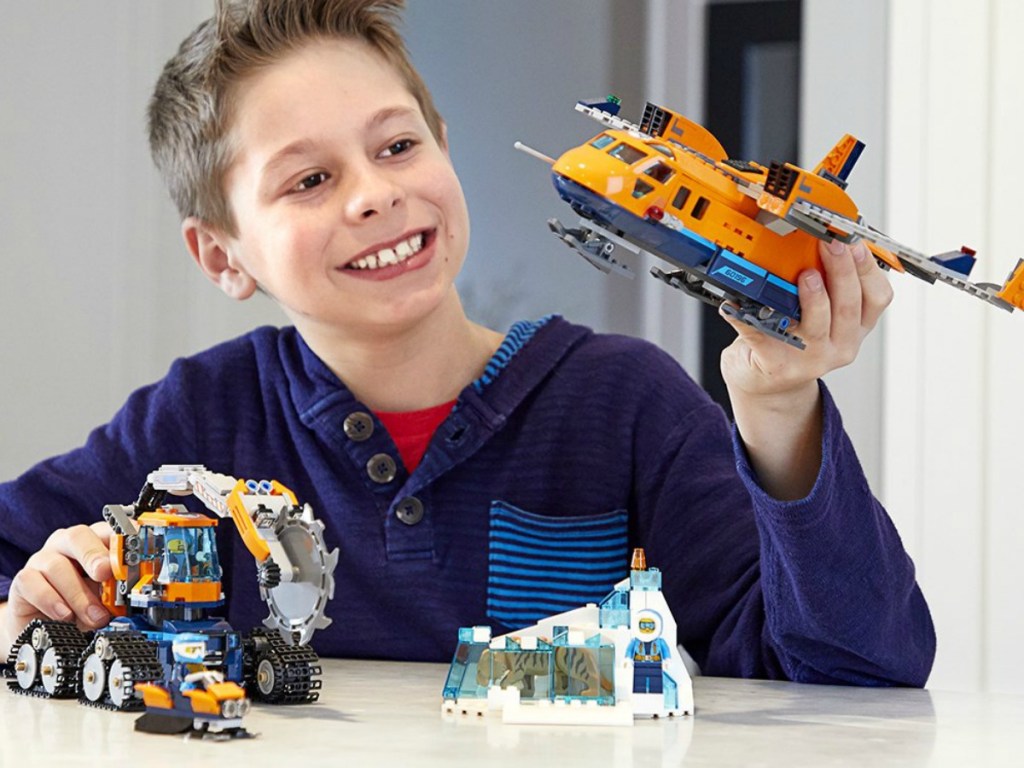 Boy playing with a LEGO City set with a plane