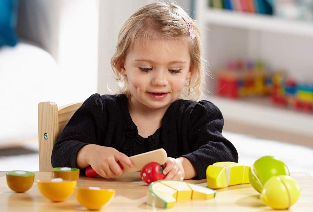 girl playing with Melissa & Doug Cutting Fruit Set