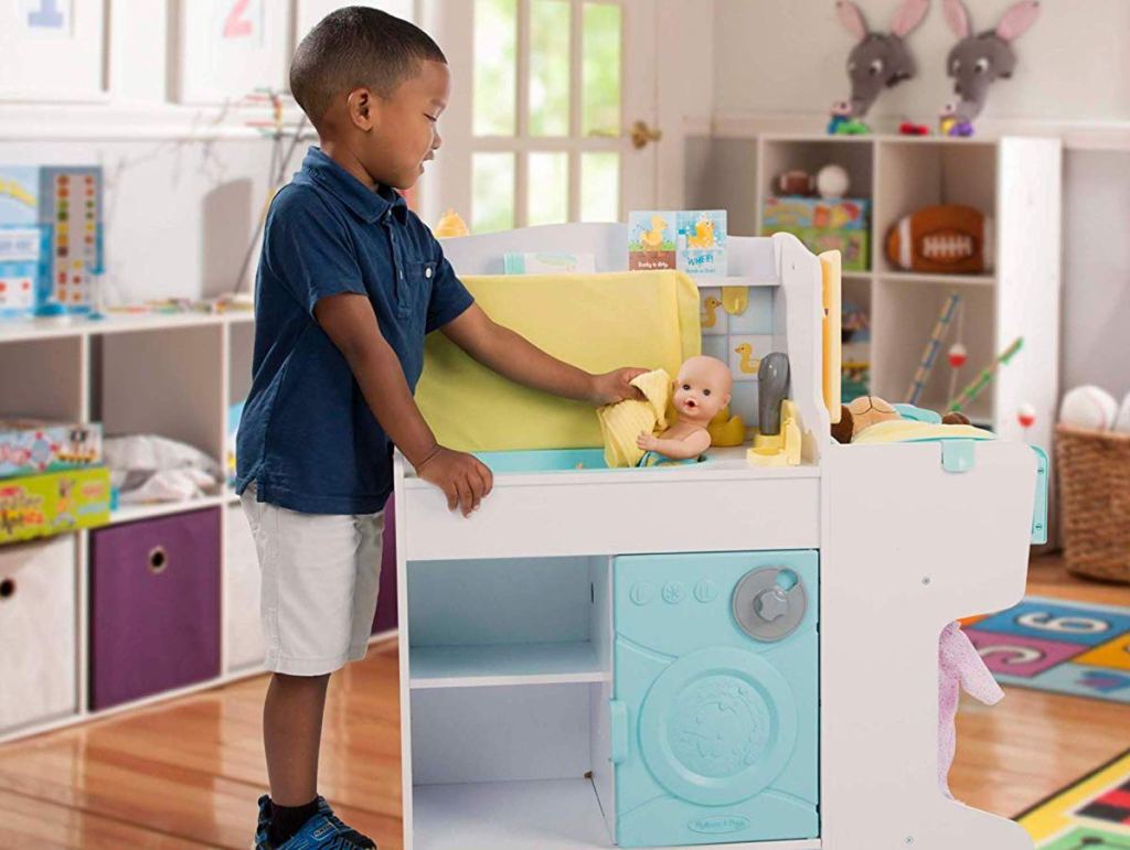 boy playing with Melissa & Doug Mine to Love Baby Care Activity Center