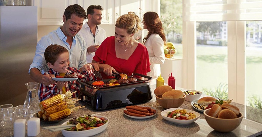 people usig Philips Smoke-less Indoor BBQ Grill on counter surrounded by food