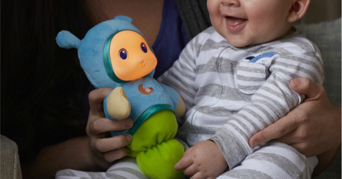 baby holding Playskool Gloworm toy