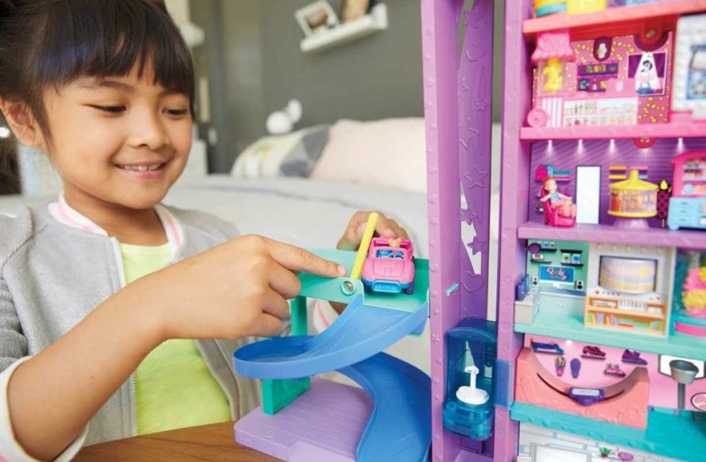 girl playing with Polly Pocket Mega Mall using car on driving ramp