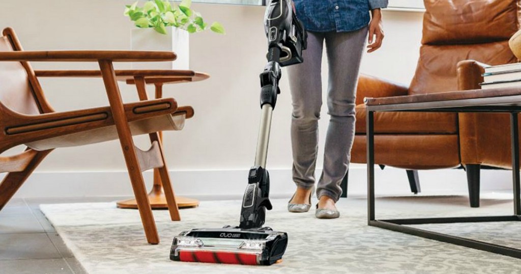 Woman vacuuming using the Shark ION Cord-Free MultiFLEX Vacuum F80 in living room on area rug