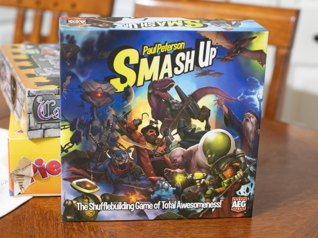 Smash Up Card Game in front of stack of games