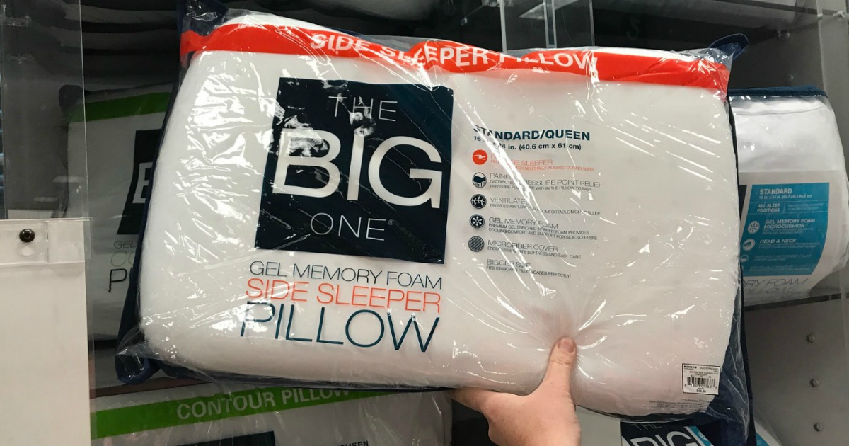 Hand holding The Big One gel side sleeper pillow in package in store in front of display