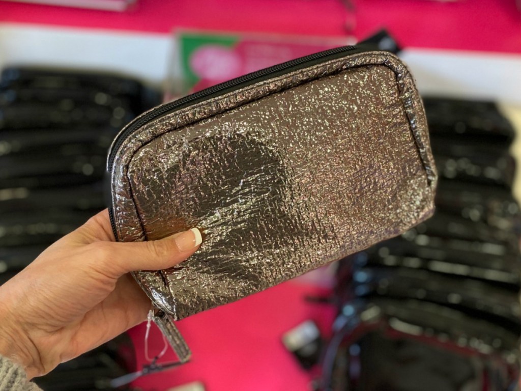 Woman holding a shiny Makeup bag filled with freebies