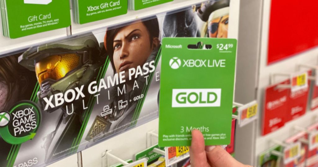 woman holding Xbox Live Gold card with xbox game pass ultimate banner in the background