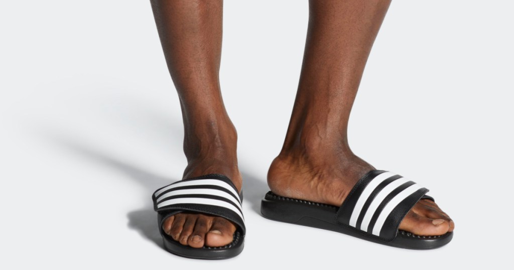 man wearing pair of adidas slides