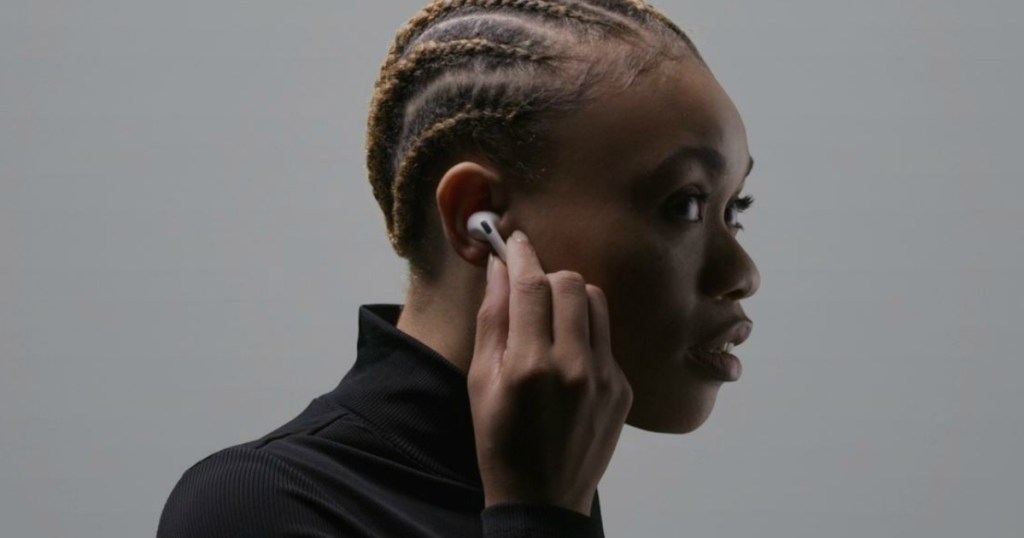 woman holding earbud in ear