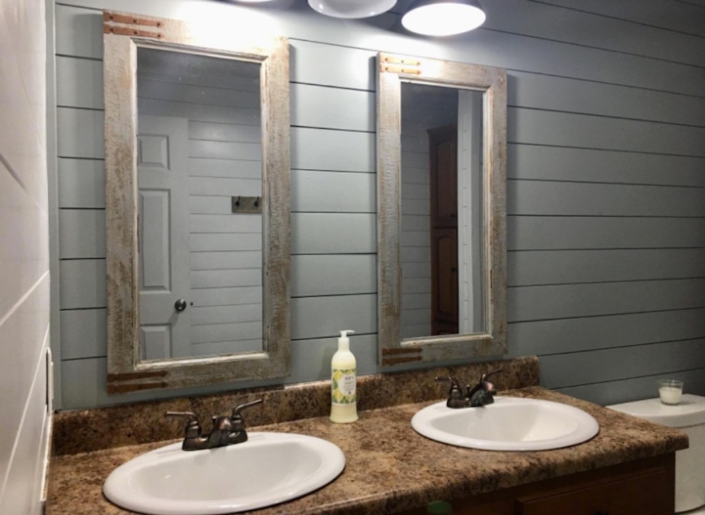 two rectangular mirrors hanging in bathroom with white vanity sinks 