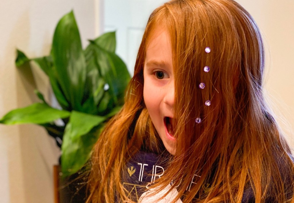 girl with red hair acting surprising with purple gems in her hair 