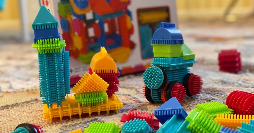 different shapes of colorful bristle blocks on floor with box 