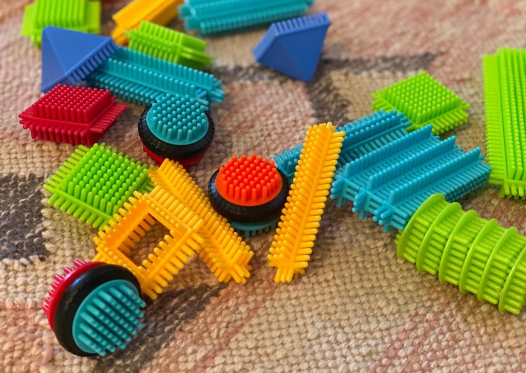 colorful random bristle blocks scattered on rug floor 