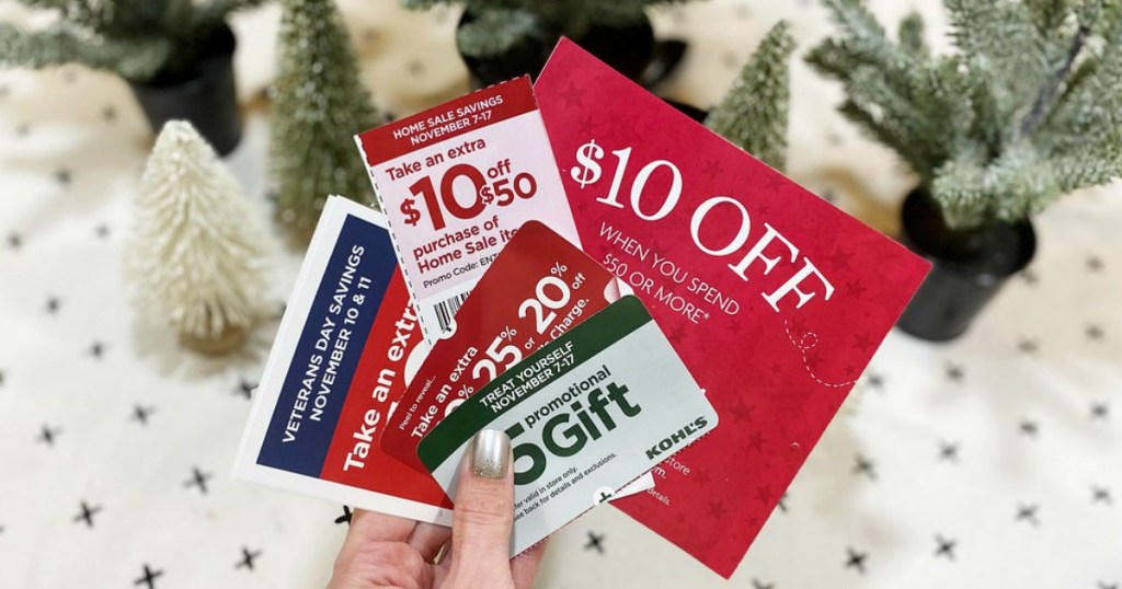 woman holding handful of coupons in front of artificial Christmas trees