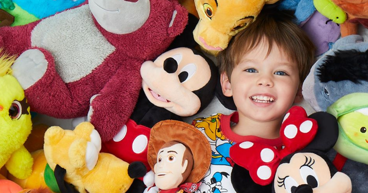 kid in pile of disney plushies