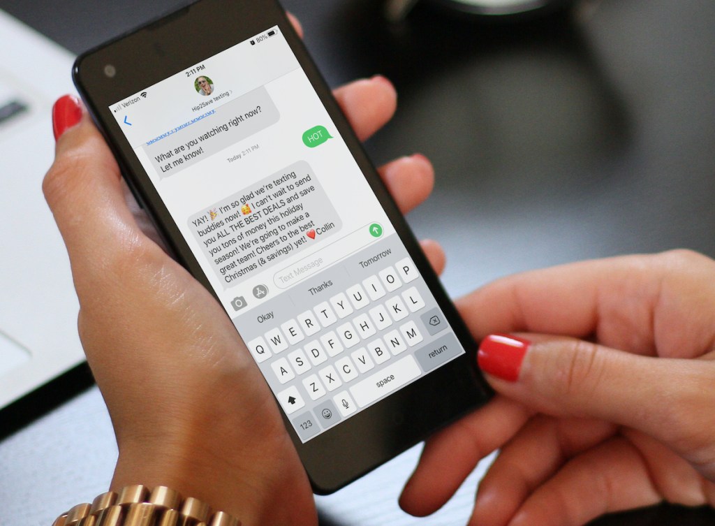 woman holding cell phone with hot texts on screen