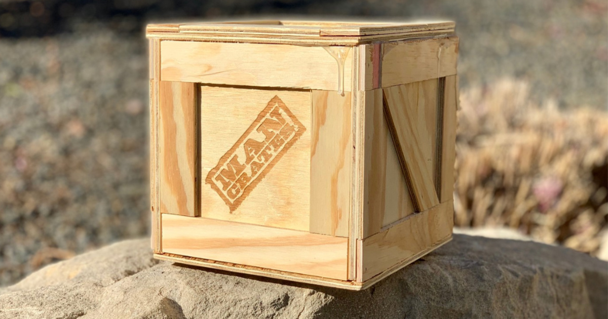 man-crates-wooden-crate-on-a-large-rock