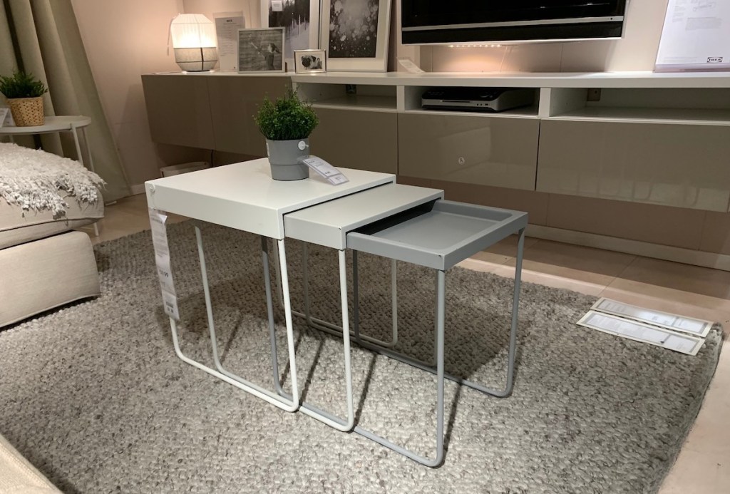 three neutral colored nesting tables in living room with plant on top 