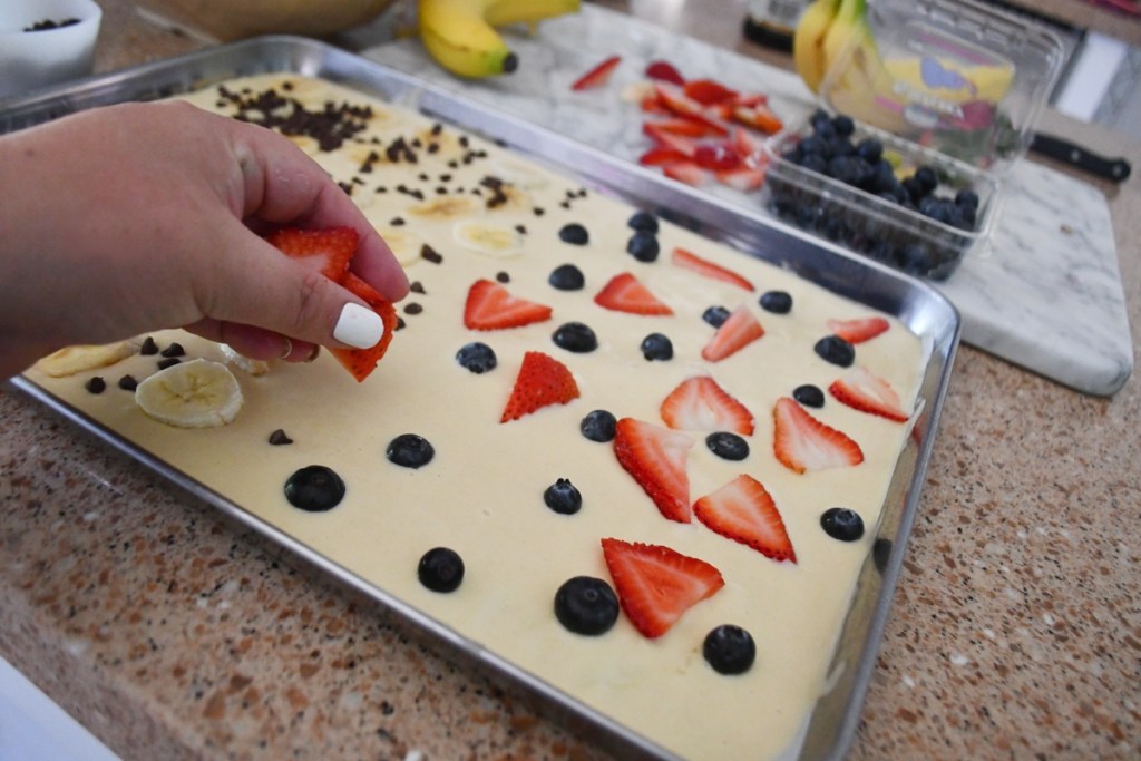 adding strawberries to sheet pan pancakes