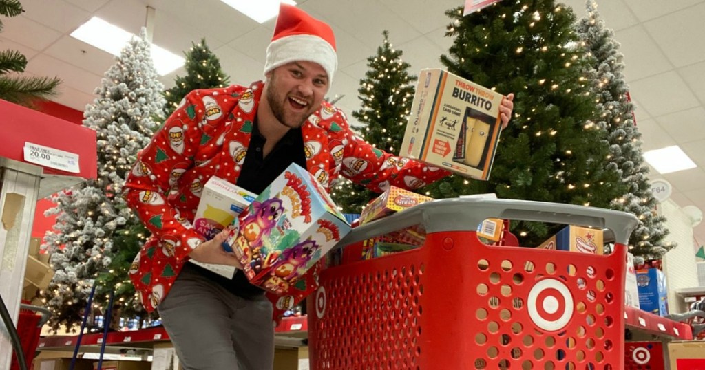 man with santa hat on holding board games at Target by shopping cart