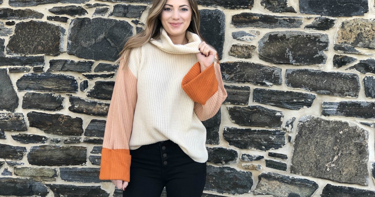 woman wearing orange and cream sweater with bell sleeves 