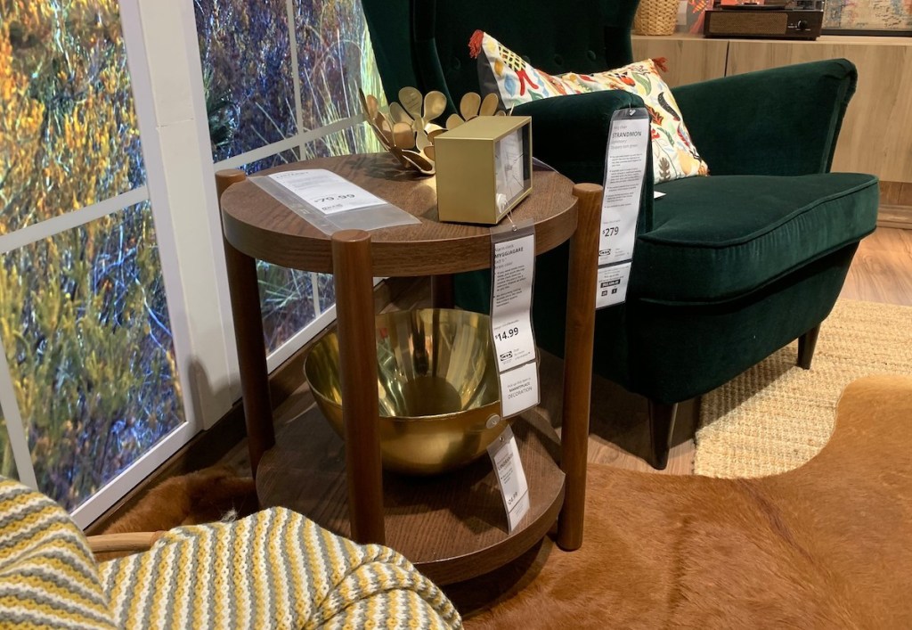 dark wood round side table next to velvet chair in living room 