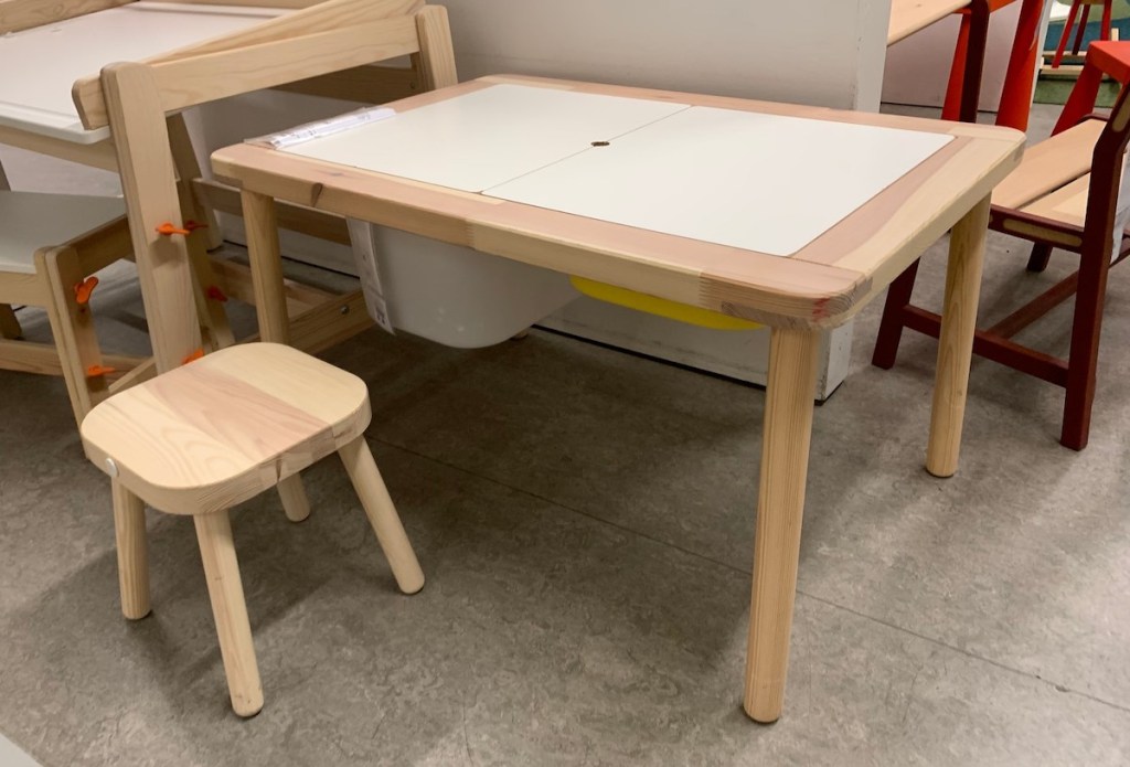 wood table and stools sitting on concrete floor 