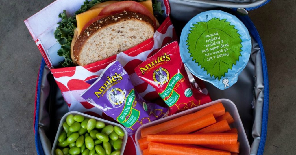 Annie's Really Peely snacks in a lunch box with a sandwich, vegetables, and a yogurt