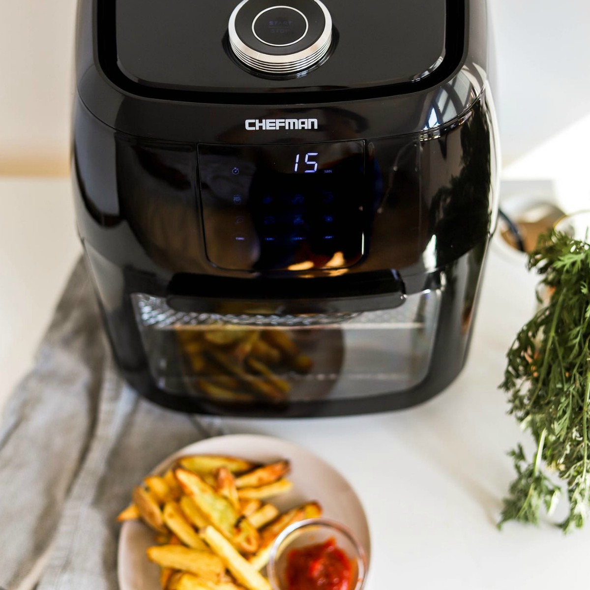 Black digital air fryer near bowl of fries