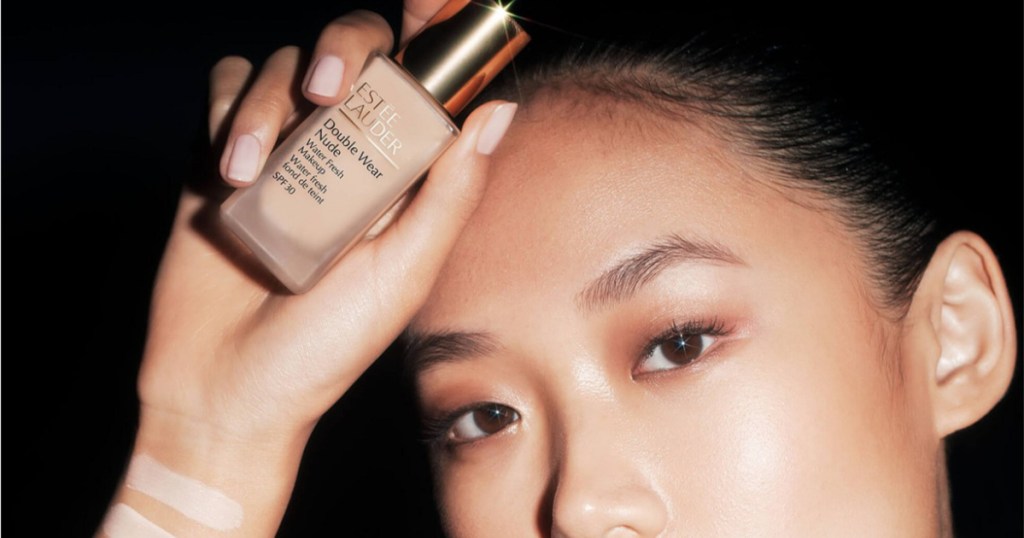 woman holding estee lauder foundation bottle