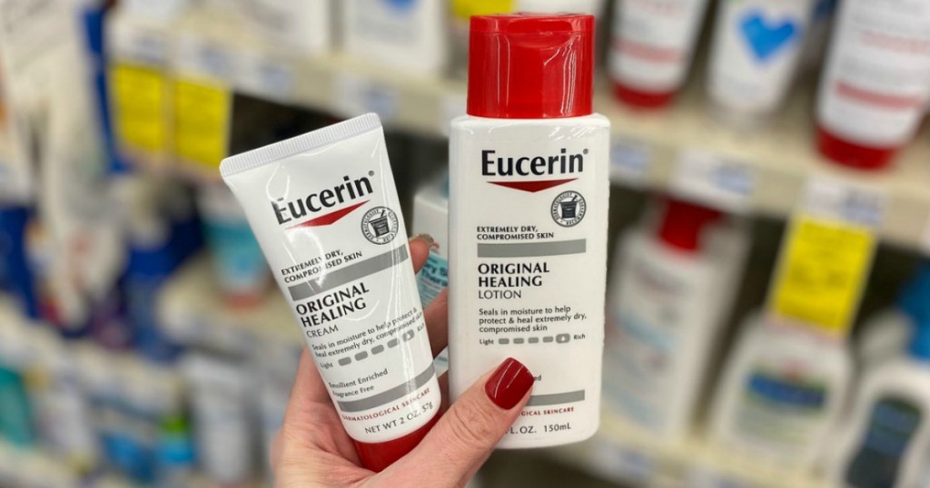 Woman holding two Eucerin healing products in hand near in-store display