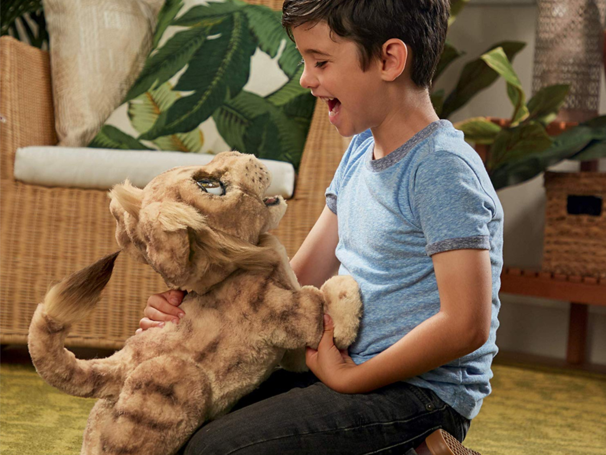 kid playing with interactive lion plush