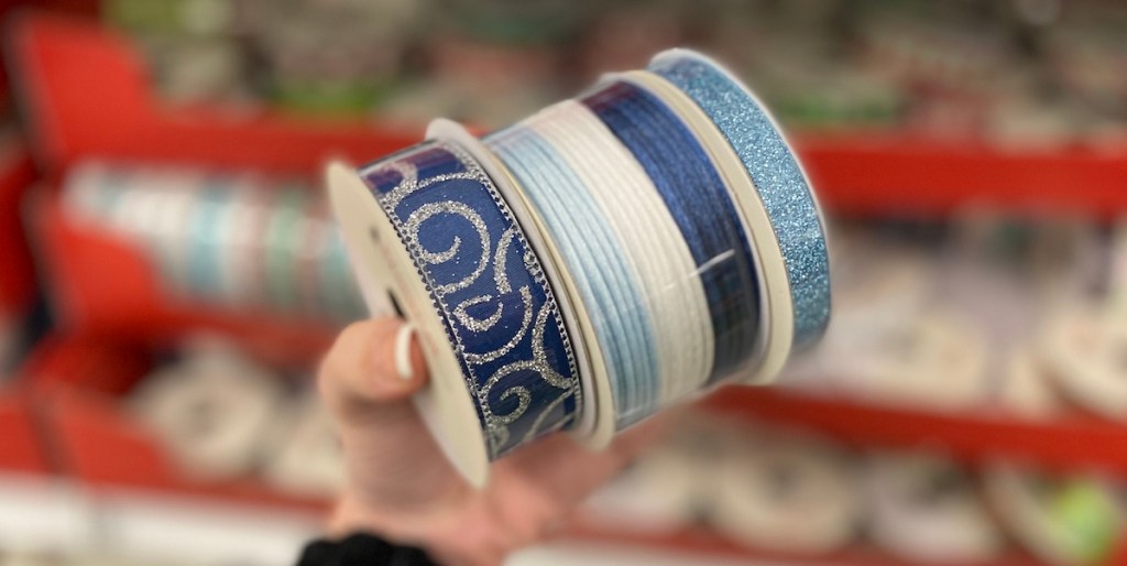 hand holding spools of Holiday Ribbon