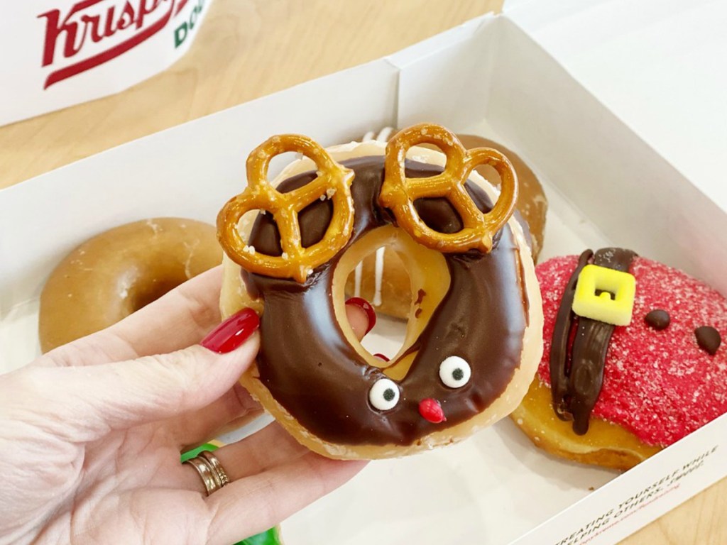 Krispy lady holding a Kreme Reindeer Doughnut