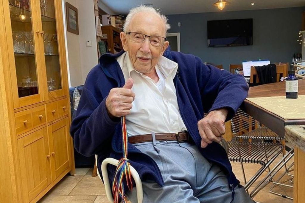 An old man sitting in a chair in a kitchen