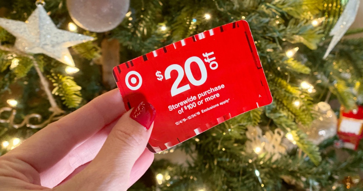 Woman holding Target coupon in front of Christmas Tree