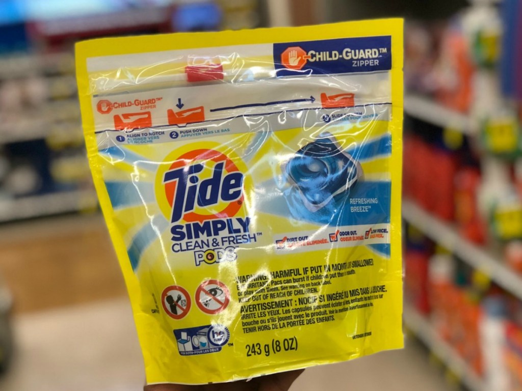 Tide pods package in hand in store near shelf