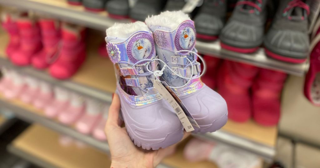 woman hand holding toddler girls frozen winter boots in store at target